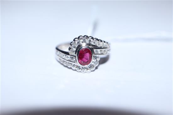 A modern stylish 18ct white gold, ruby and diamond oval cluster ring, with diamond set shoulders, size L/M.